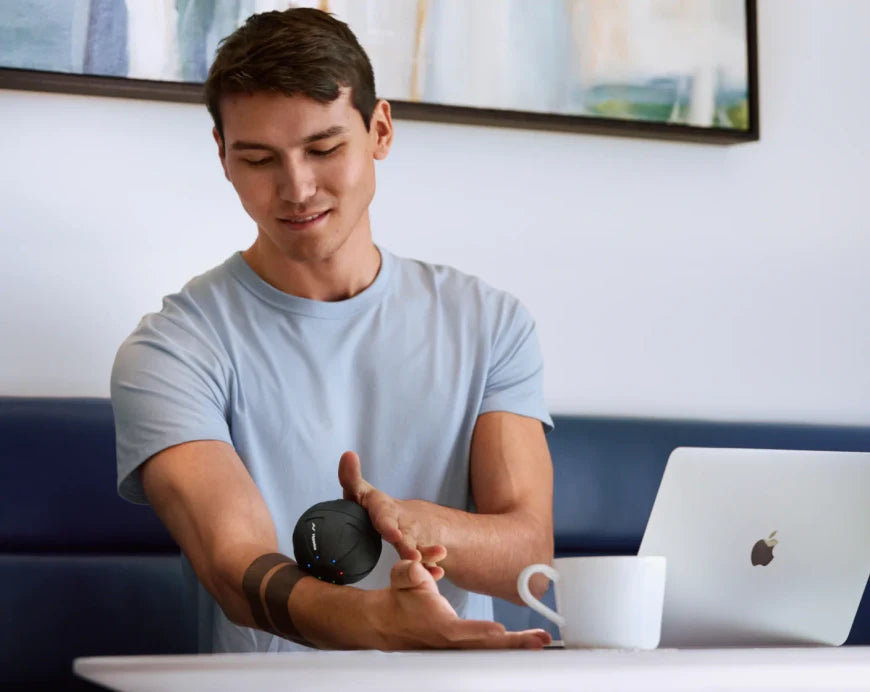 Hypersphere massage ball used for muscle recovery at the desk.